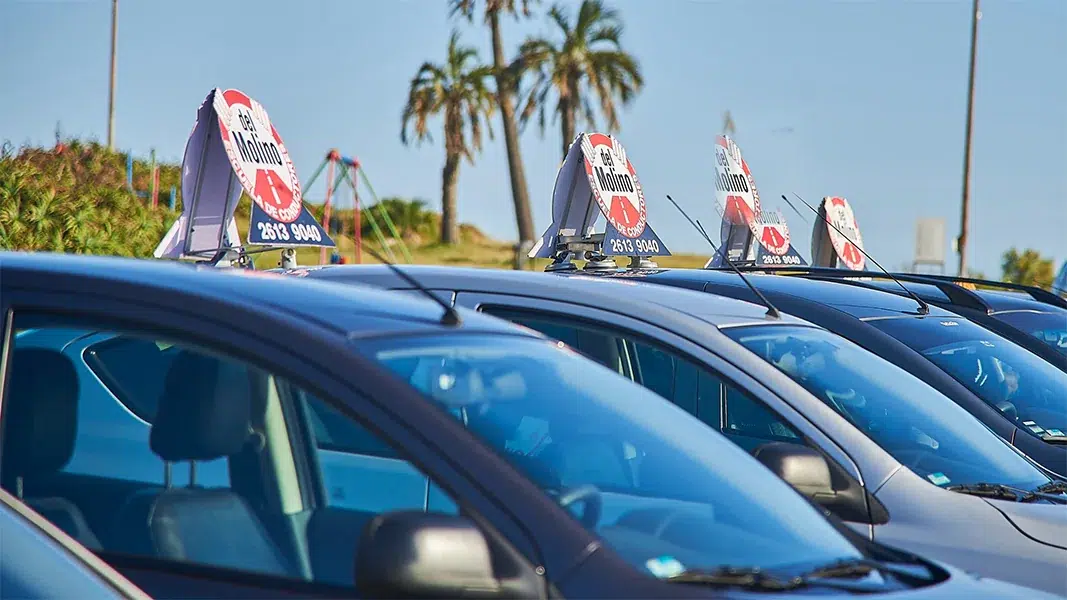 Coches escuela de Academia Del Molino con sus carteles, listos para la evaluación de choferes de empresas